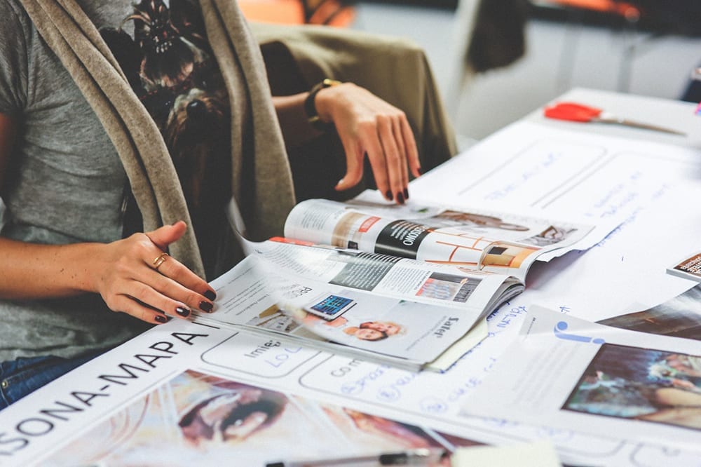 A woman peruses a stack of glossy magazines