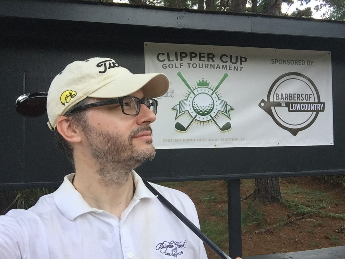 Mike Bragg stands in front of the Clipper Cup Golf Tournament banner. The annual tournament raises money for Bluffton Self Help.