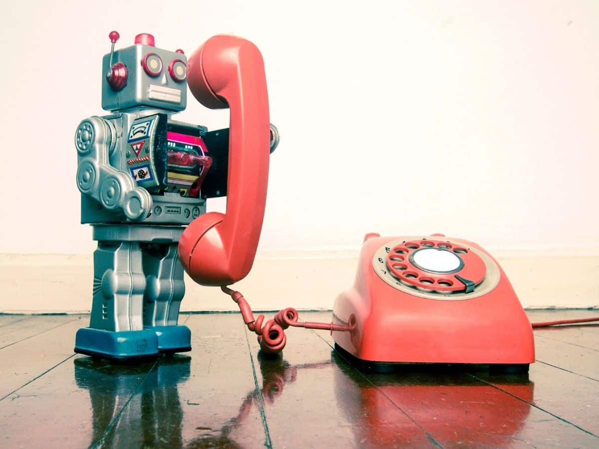 toy robot holds a rotary phone to its ear
